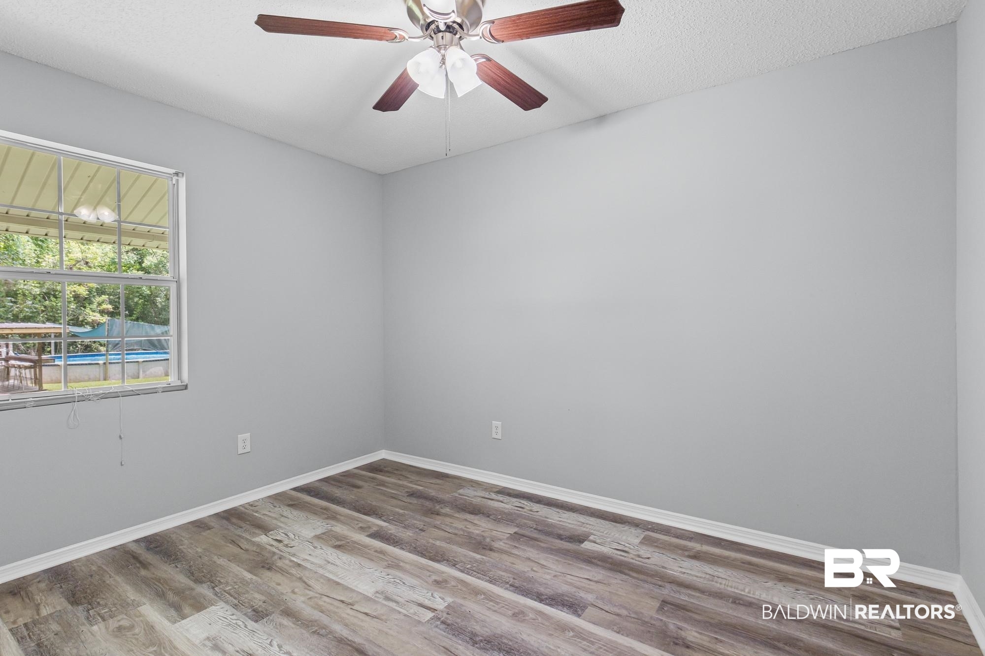 6933 Burbank Court Mobile, AL 36619 - Photo 20 of 25 Interior room featuring wood-finish flooring, light gray walls, and white baseboards
