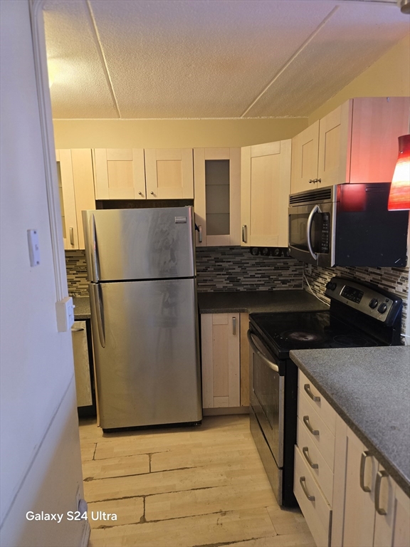 200 Swanton Street, Unit T35 Winchester, MA 01890 - Photo 7 of 36 a kitchen with stainless steel appliances granite countertop a sink stove and refrigerator