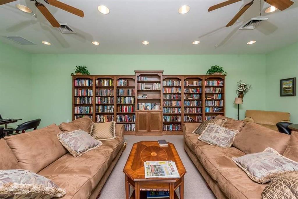 617 Southwest 34th Cove Okeechobee, FL 34974 - Photo 31 of 39 a living room with a couch and a bookshelf with wooden floor