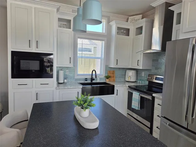 a kitchen with stainless steel appliances a stove a sink microwave and cabinets