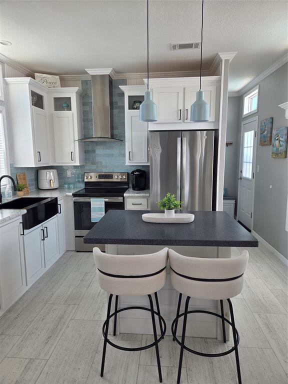 617 Southwest 34th Cove Okeechobee, FL 34974 - Photo 8 of 39 a kitchen with stainless steel appliances granite countertop a stove a sink a microwave a refrigerator and white cabinets