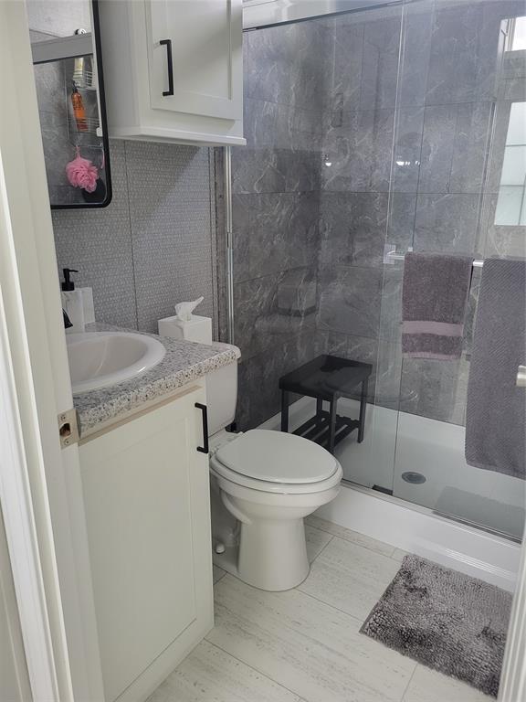 617 Southwest 34th Cove Okeechobee, FL 34974 - Photo 10 of 39 a bathroom with a granite countertop toilet a sink and a shower