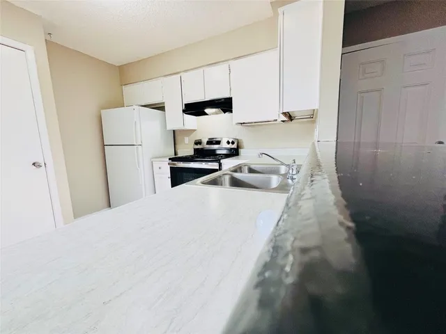 a kitchen with wooden floors and appliances