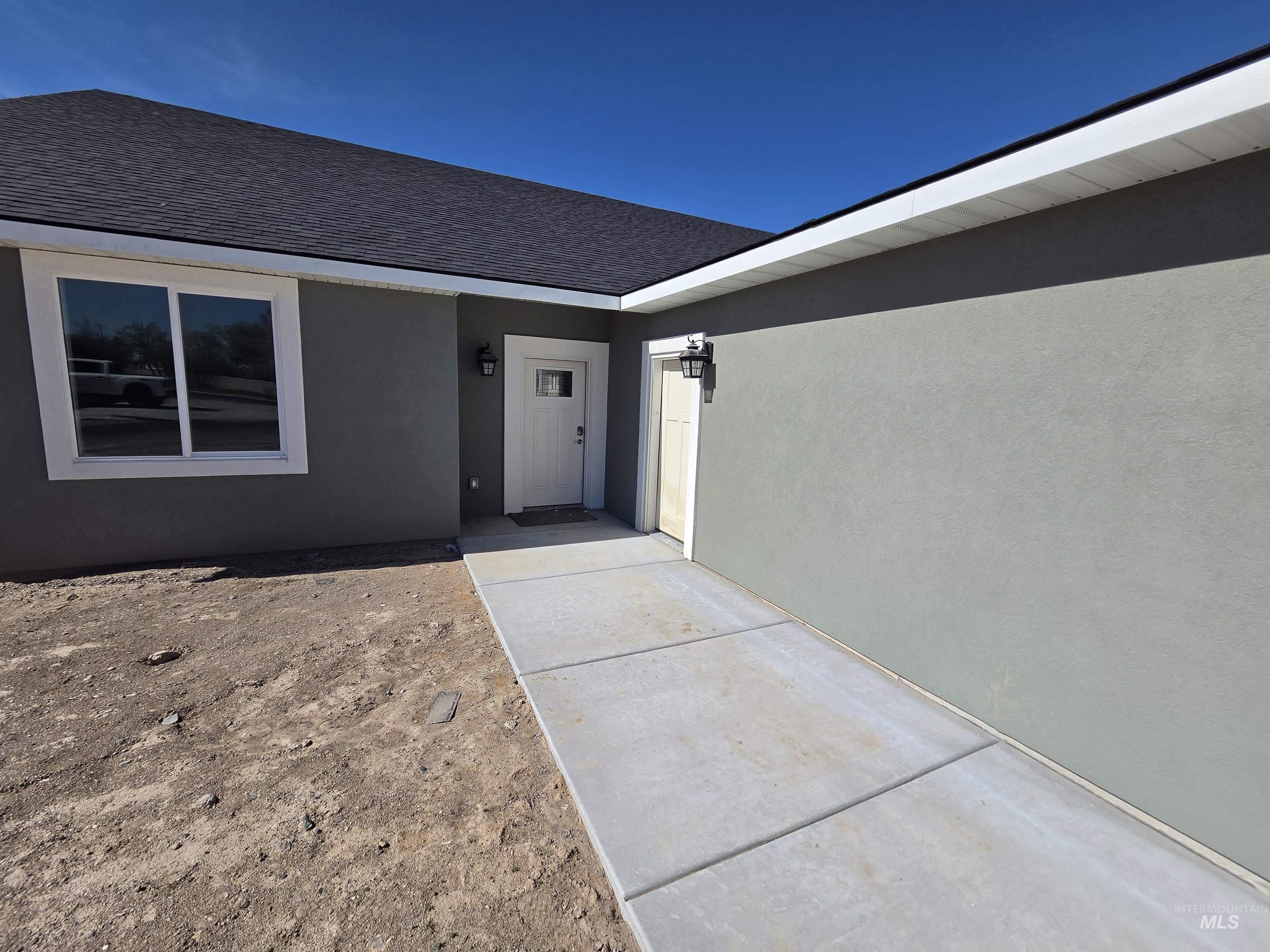 39 Lakeside Loop Burley, ID 83318 - Photo 3 of 15 View of exterior entry featuring stucco siding and a shingled roof