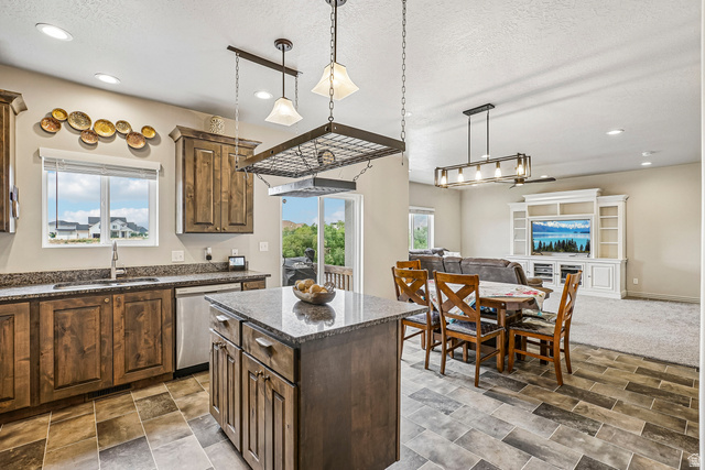 203 North 1900th Street West Mapleton, UT 84664 - Photo 11 of 48 Kitchen featuring wood cabinetry, granite countertops, an undermount sink, and a center island with storage