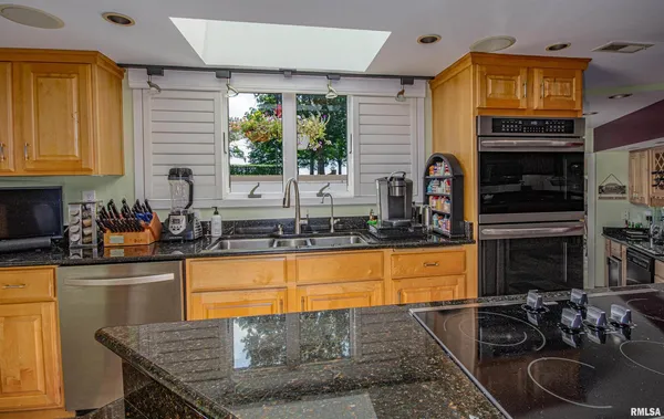 a kitchen with white cabinets and sink