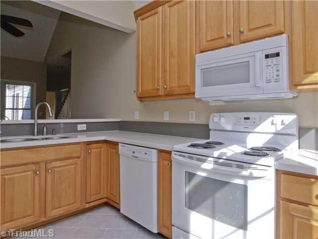 7809 Perthshire Drive Oak Ridge, NC 27310 - Photo 6 of 15 Kitchen. Beautiful cabinets with lots of storage. Tile floor, and solid surface counter tops compliment the overall feel of this ready to cook in kitchen. Dishwasher, microwave, stove, and fridge remain!