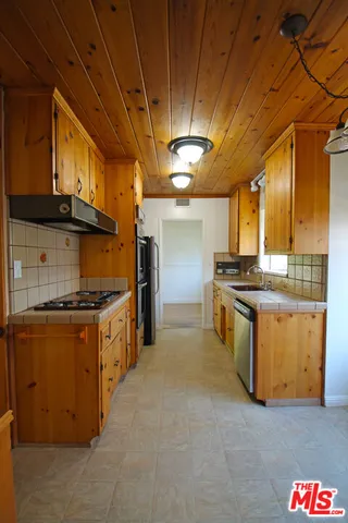 a kitchen with stainless steel appliances granite countertop a sink a stove and a refrigerator