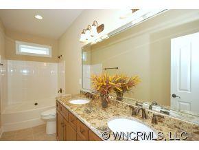 144 Sunny Ridge Road Laurel Park, NC 28739 - Photo 11 of 12 a bathroom with a sink a mirror and a shower