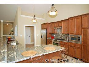 144 Sunny Ridge Road Laurel Park, NC 28739 - Photo 5 of 12 a kitchen with stainless steel appliances granite countertop a stove refrigerator and cabinets