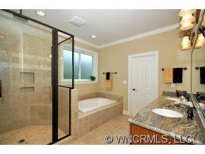 144 Sunny Ridge Road Laurel Park, NC 28739 - Photo 9 of 12 a bathroom with a granite countertop sink a mirror and a bathtub