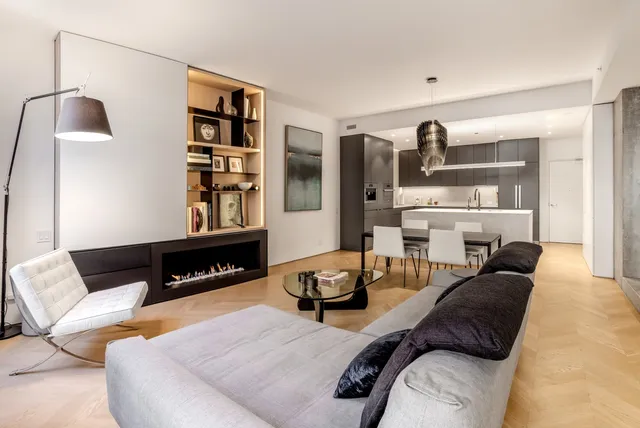 a kitchen with stainless steel appliances kitchen island a table chairs in it and wooden floors