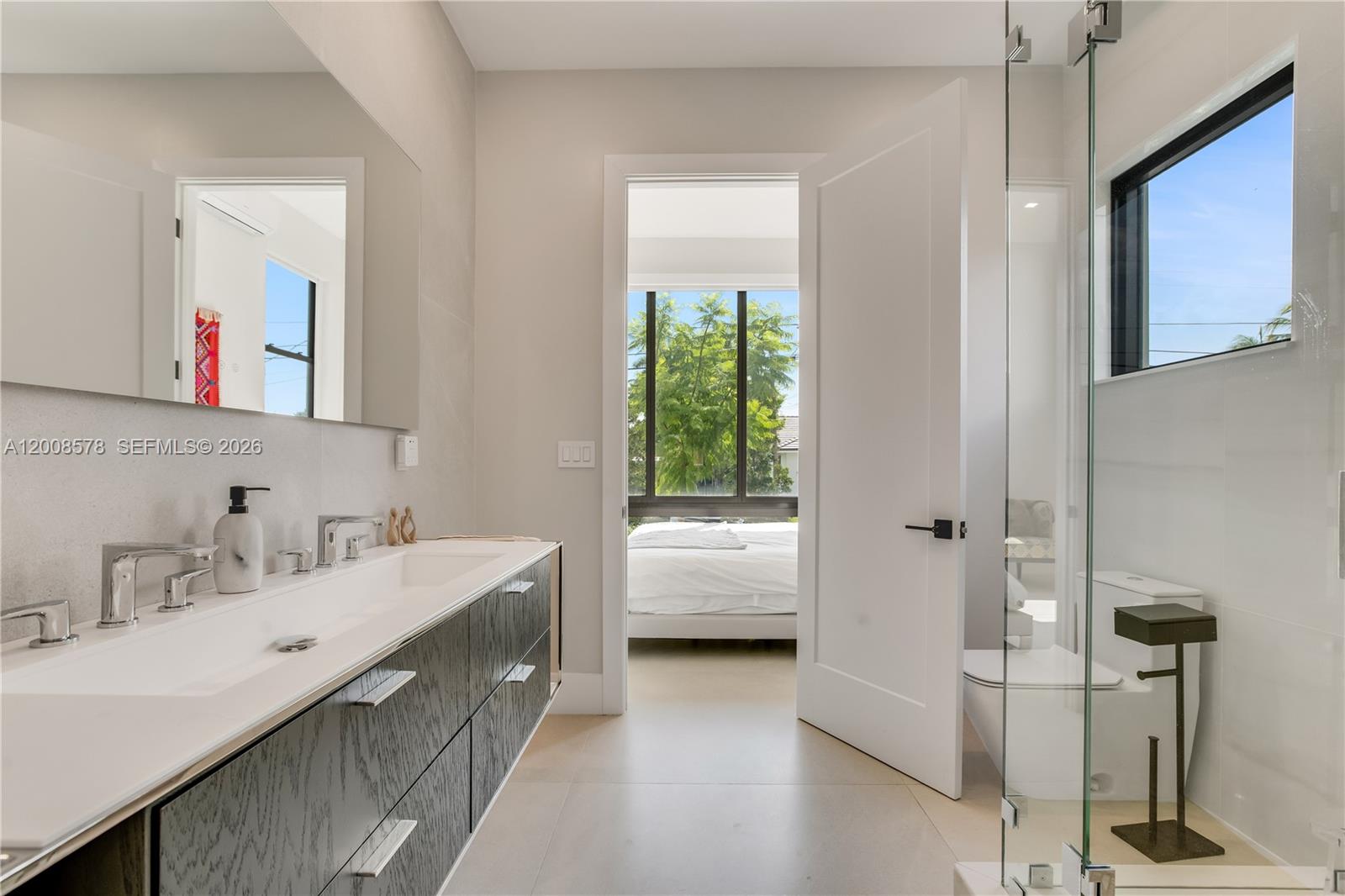 8826 Froude Avenue Surfside, FL 33154 - Photo 26 of 51 a en suite bathroom with a double vanity sink a mirror and window