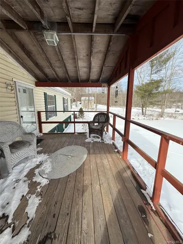 a view of a patio with wooden floor a barbeque oven and dining table