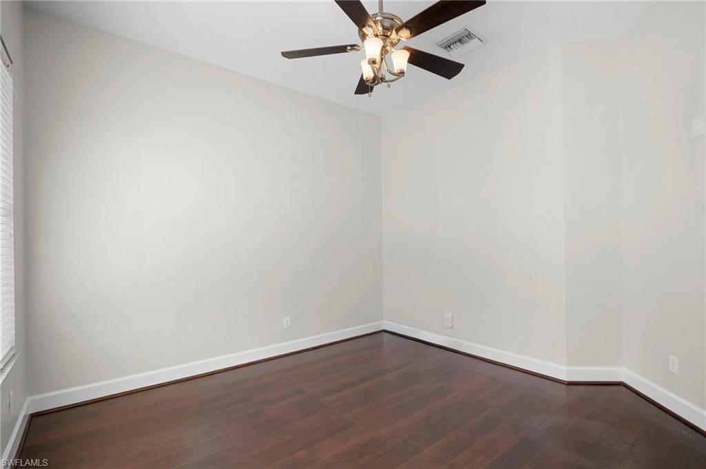 7915 Founders Circle Naples, FL 34104 - Photo 16 of 25 Unfurnished room with dark wood-type flooring and a ceiling fan