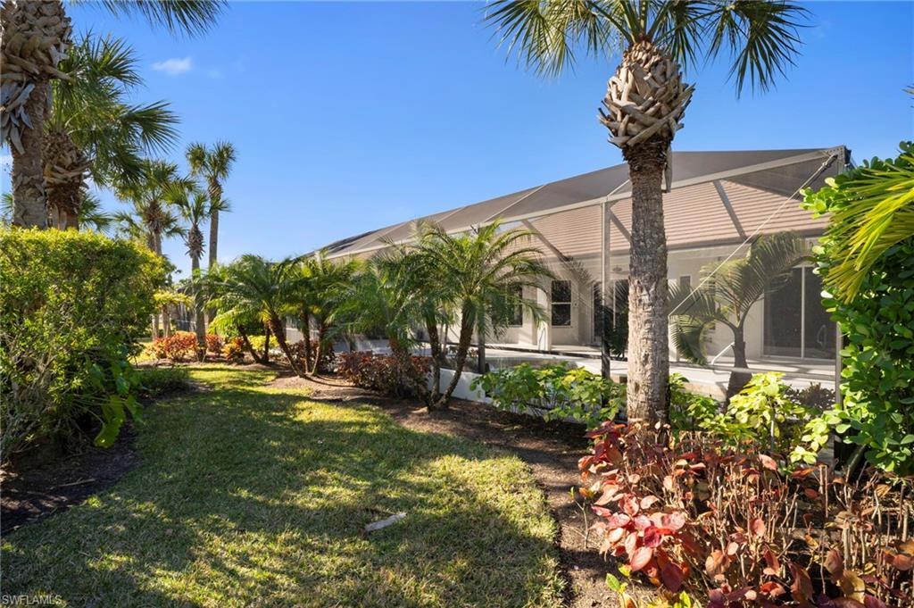 7915 Founders Circle Naples, FL 34104 - Photo 23 of 25 View of grassy yard featuring a sunroom and a lanai