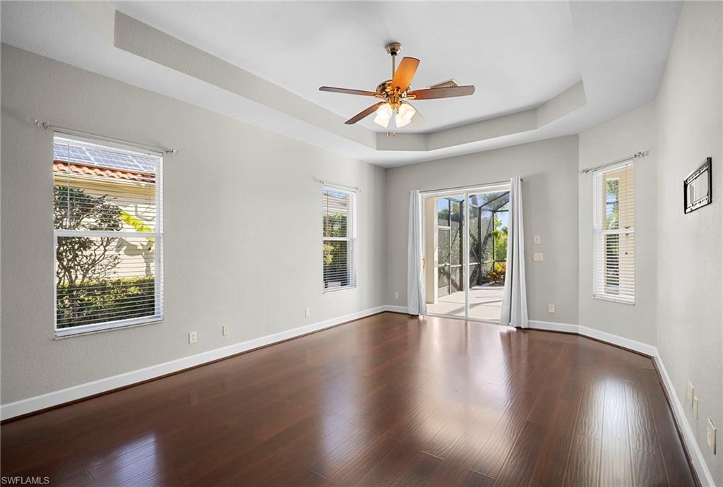 7915 Founders Circle Naples, FL 34104 - Photo 9 of 25 Unfurnished room with a raised ceiling, wood finished floors, and a ceiling fan