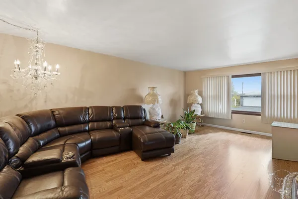 a living room with furniture a chandelier and a window