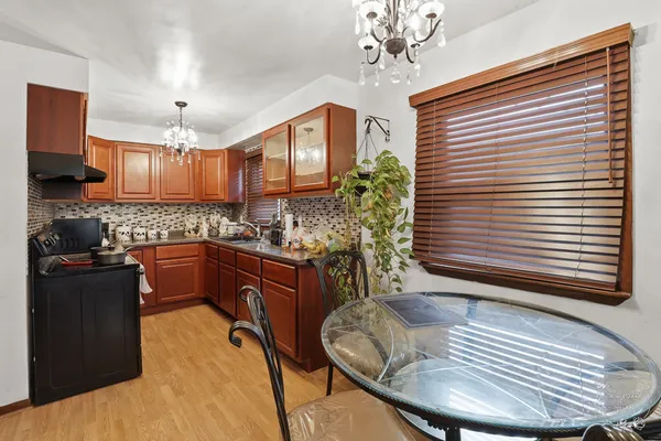 a kitchen with a chandelier stainless steel appliances and cabinets