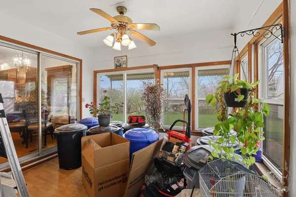 a living room with patio furniture and a potted plant