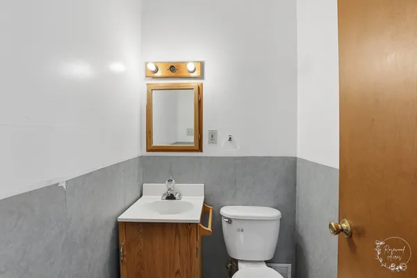 a bathroom with a toilet sink and mirror