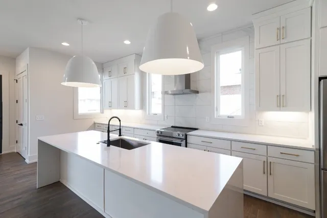 a kitchen with kitchen island white cabinets and sink