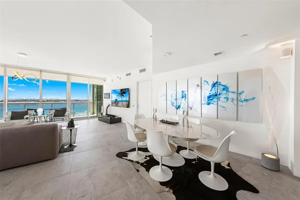 a living room with stainless steel appliances furniture and a kitchen