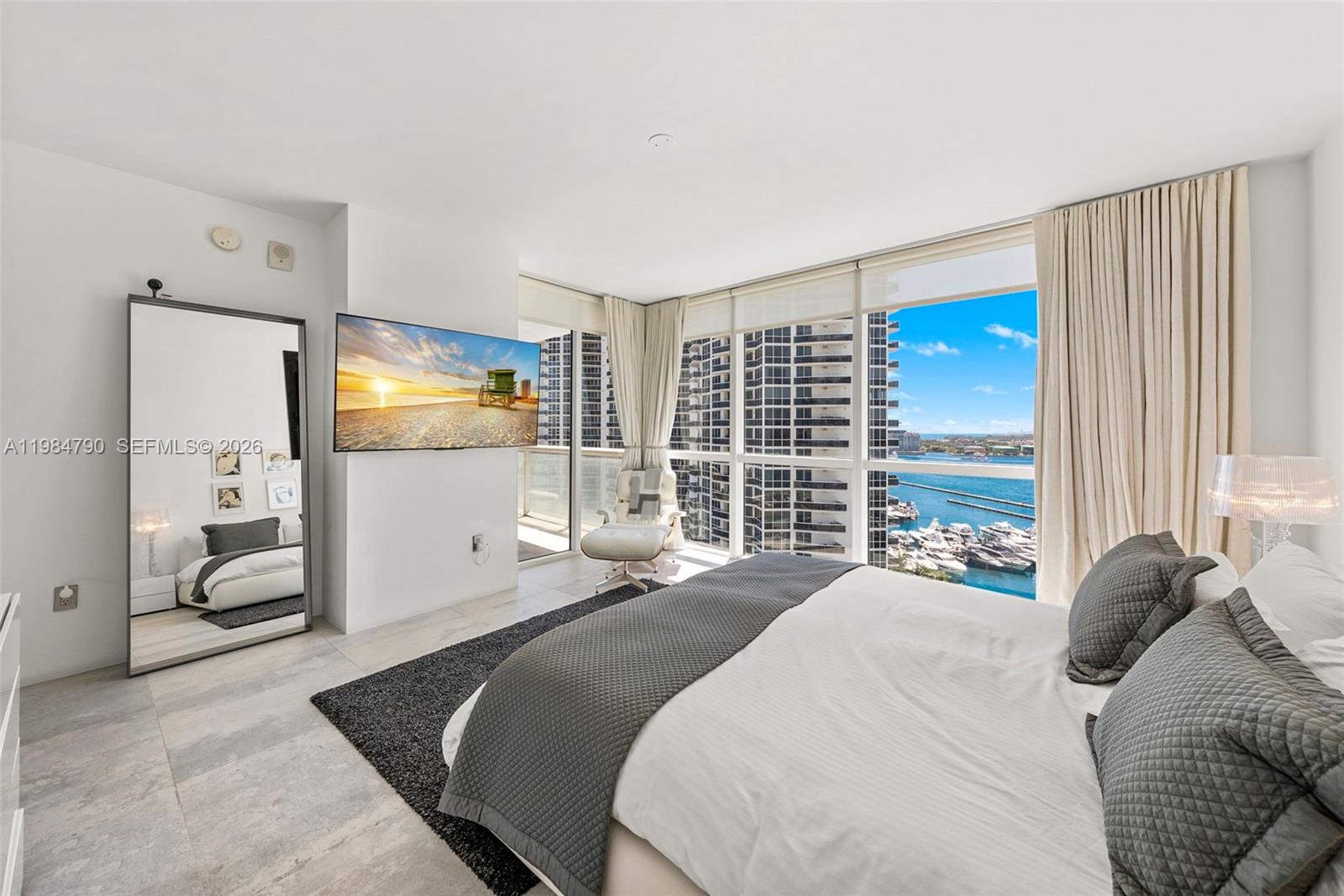 450 Alton Road, Unit 1507 Miami Beach, FL 33139 - Photo 31 of 72 a bedroom with a large bed and a flat tv screen