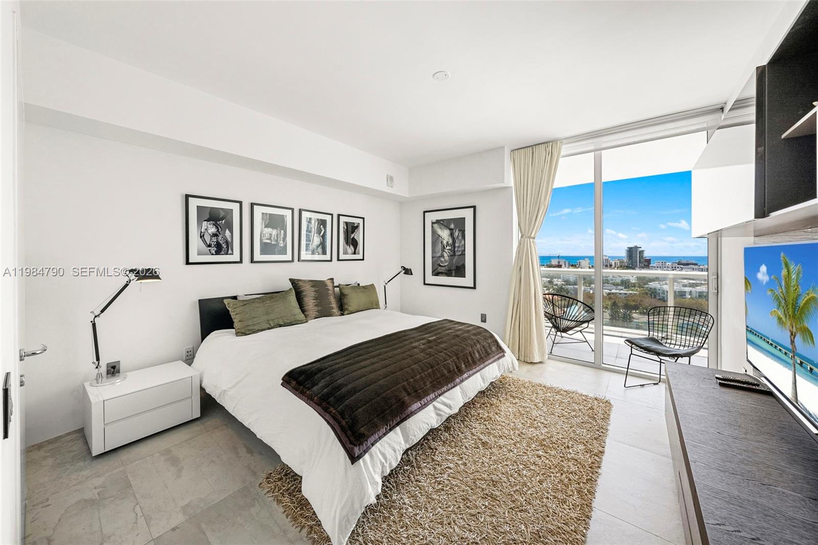 450 Alton Road, Unit 1507 Miami Beach, FL 33139 - Photo 42 of 72 a bedroom with a large bed a couch and dresser