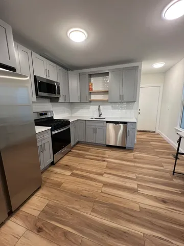 a large kitchen with stainless steel appliances granite countertop a stove and a sink