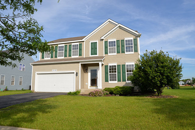 25148 Spring Street Manhattan, IL 60442 - Photo 1 of 15 a front view of a house with a garden