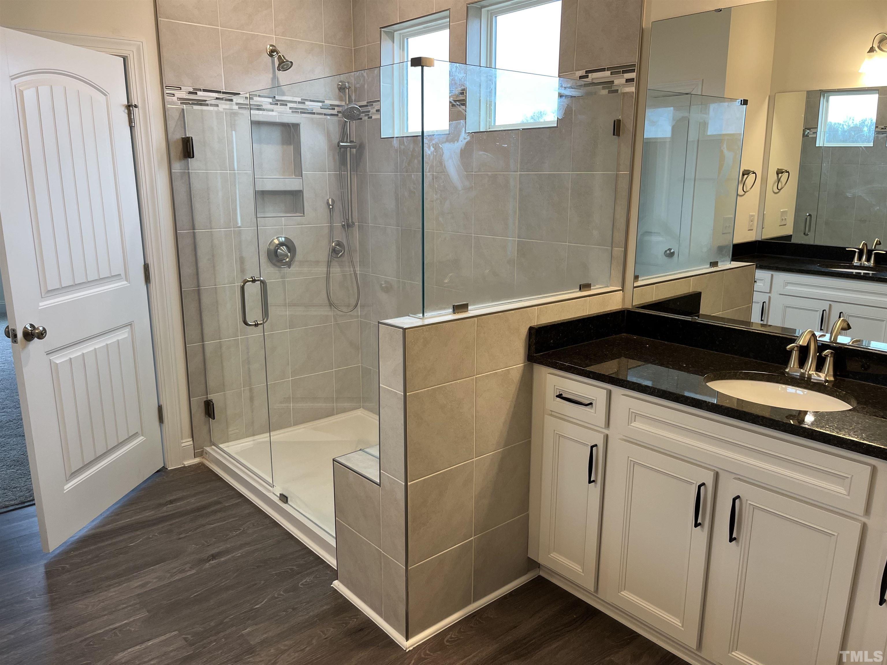 4408 Beckel Road Willow Spring, NC 27592 - Photo 12 of 24 a bathroom with a granite countertop sink a mirror and shower