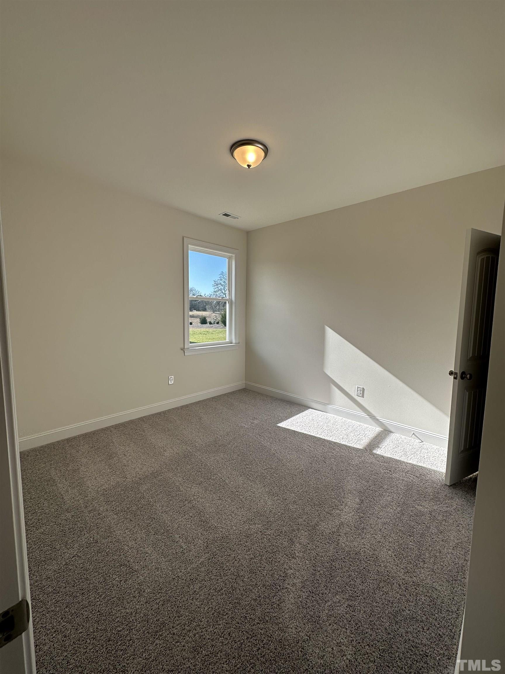 4408 Beckel Road Willow Spring, NC 27592 - Photo 5 of 24 a view of an empty room and a window