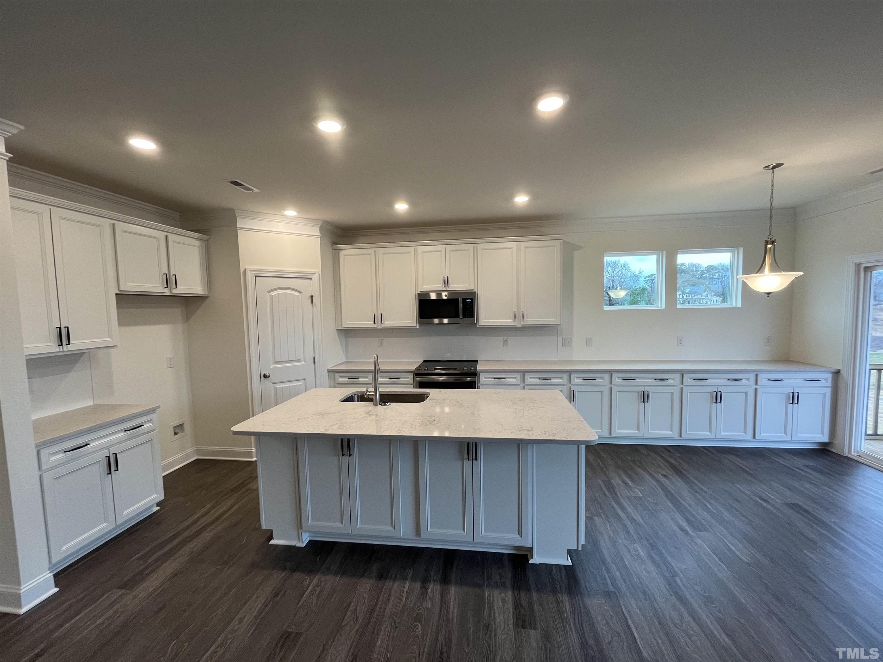 4408 Beckel Road Willow Spring, NC 27592 - Photo 8 of 24 a kitchen with kitchen island wooden floors wooden cabinets and center island