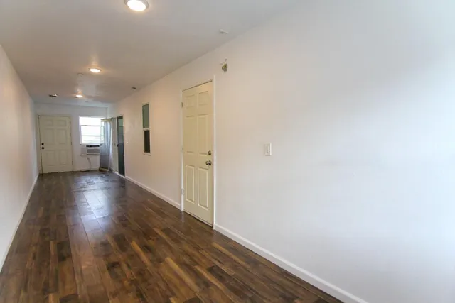 a view of a hallway with wooden floor