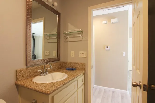 a bathroom with a granite countertop sink and a mirror