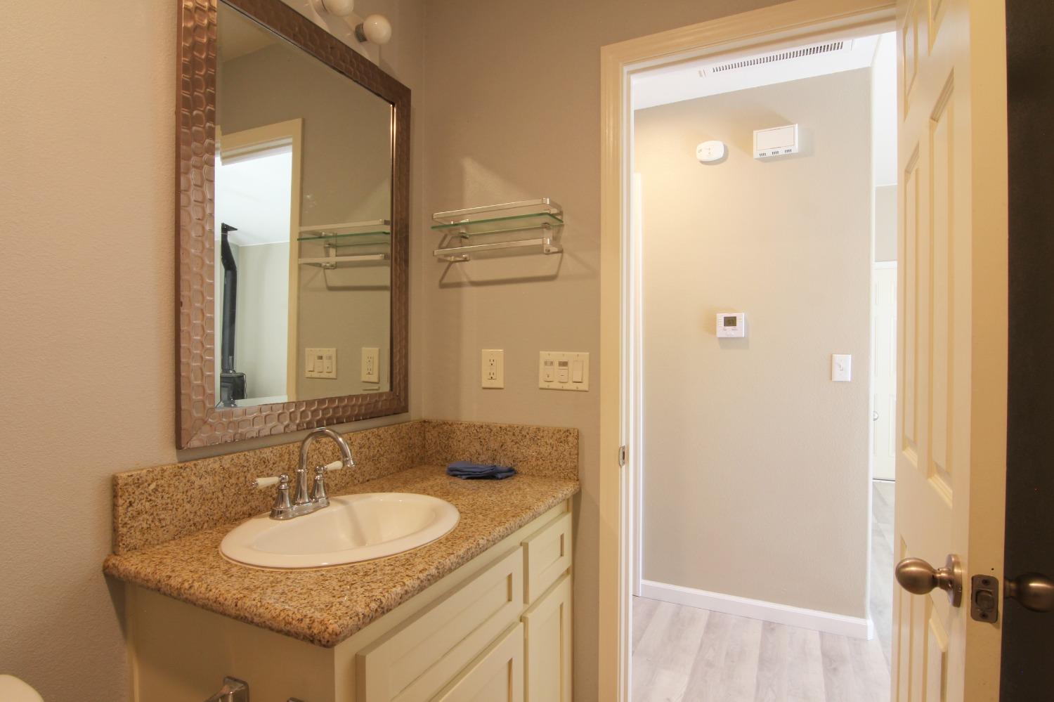 4968 Yaqui Gulch Road Mariposa, CA 95338 - Photo 16 of 37 a bathroom with a granite countertop sink and a mirror