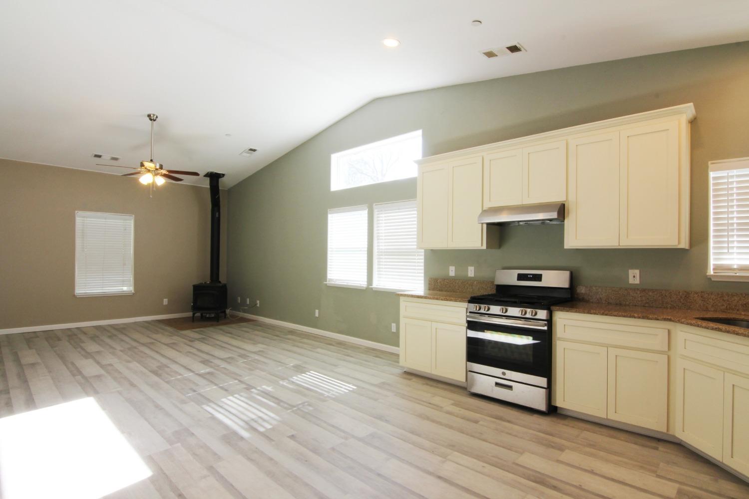 4968 Yaqui Gulch Road Mariposa, CA 95338 - Photo 7 of 37 a kitchen with granite countertop a stove a sink and a refrigerator