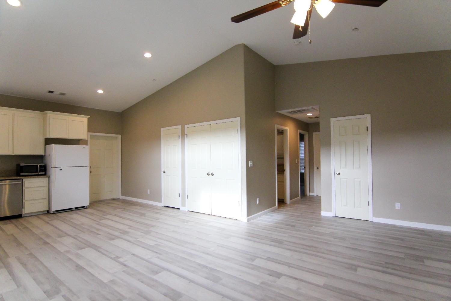 4968 Yaqui Gulch Road Mariposa, CA 95338 - Photo 8 of 37 a view of a kitchen with a refrigerator a ceiling fan and wooden floor