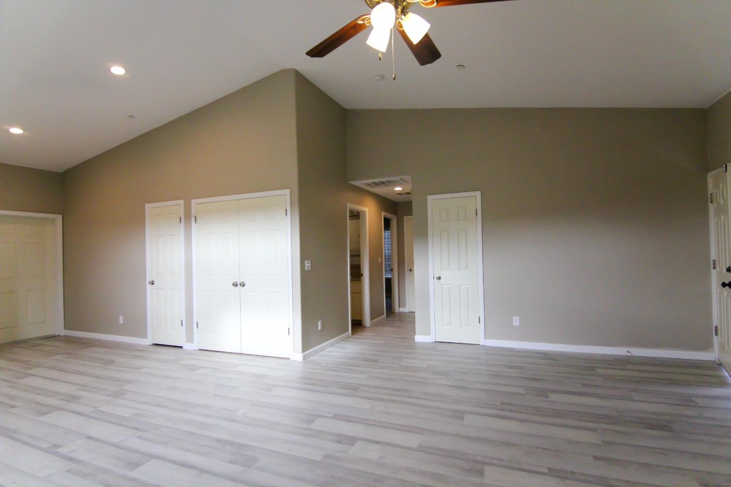 4968 Yaqui Gulch Road Mariposa, CA 95338 - Photo 10 of 37 a view of an empty room with wooden floor and ceiling fan