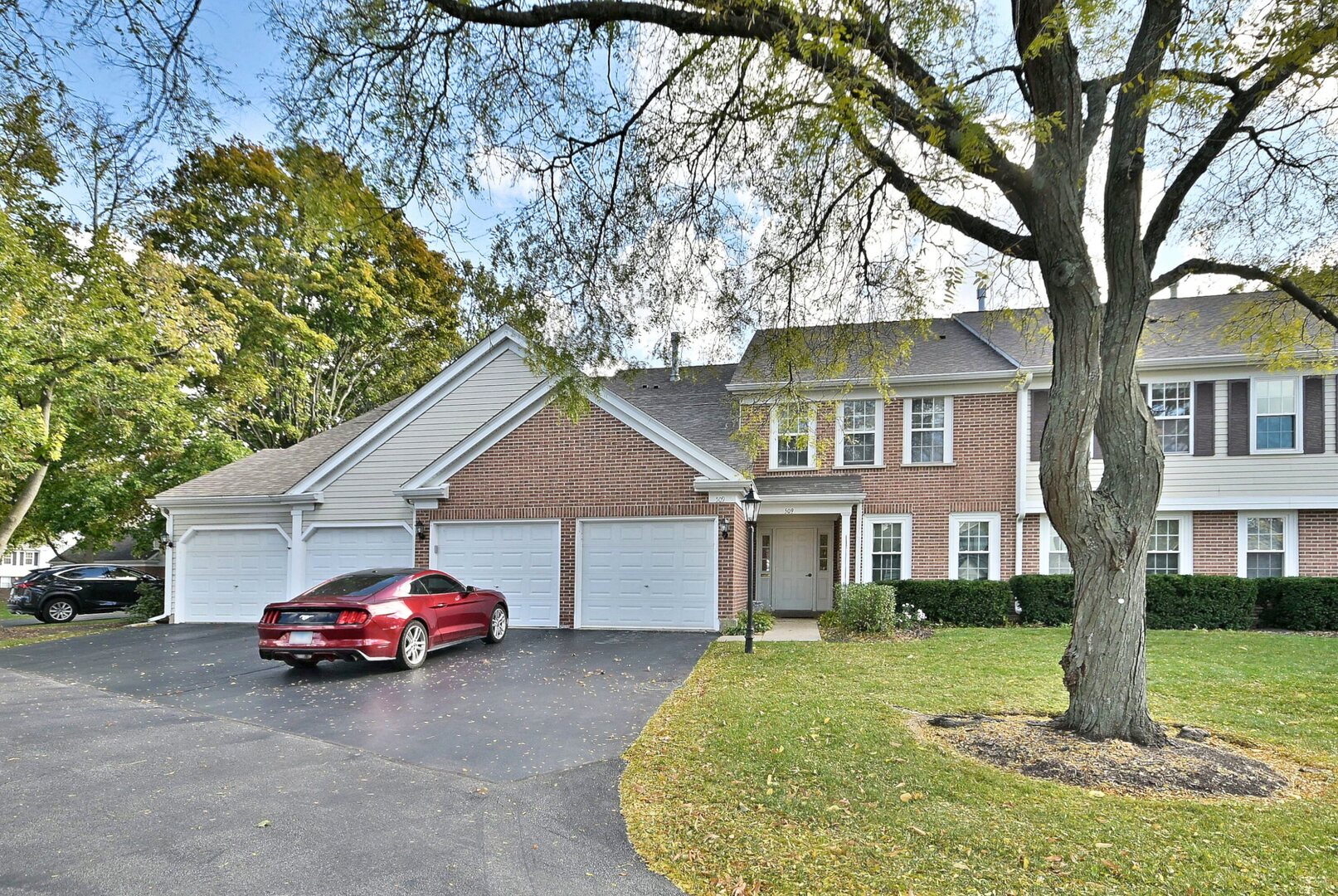 a front view of a house with a garden and trees