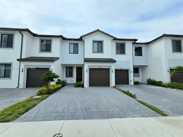 a front view of a house with a garden and a yard
