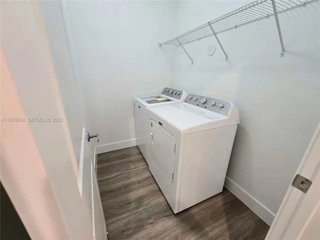 a utility room with wooden floor washer and dryer