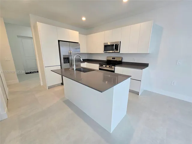 a kitchen with stainless steel appliances a refrigerator stove microwave and sink