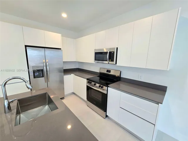 a kitchen with stainless steel appliances a stove microwave and a refrigerator