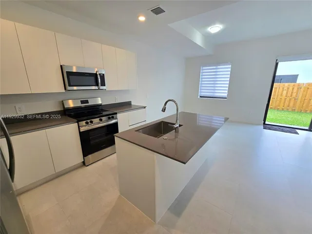 a kitchen with stainless steel appliances granite countertop a sink and a stove
