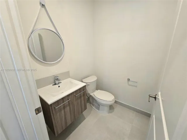 a bathroom with a toilet a sink and mirror