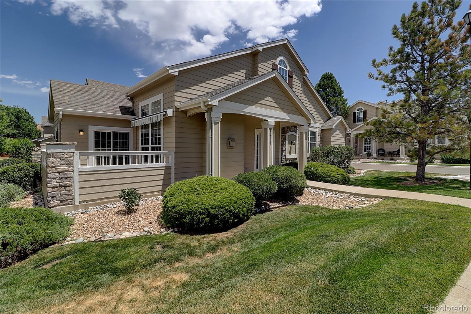 6203 Trailhead Road Highlands Ranch, CO 80130 - Photo 2 of 32 a view of a white house next to a yard with plants and trees