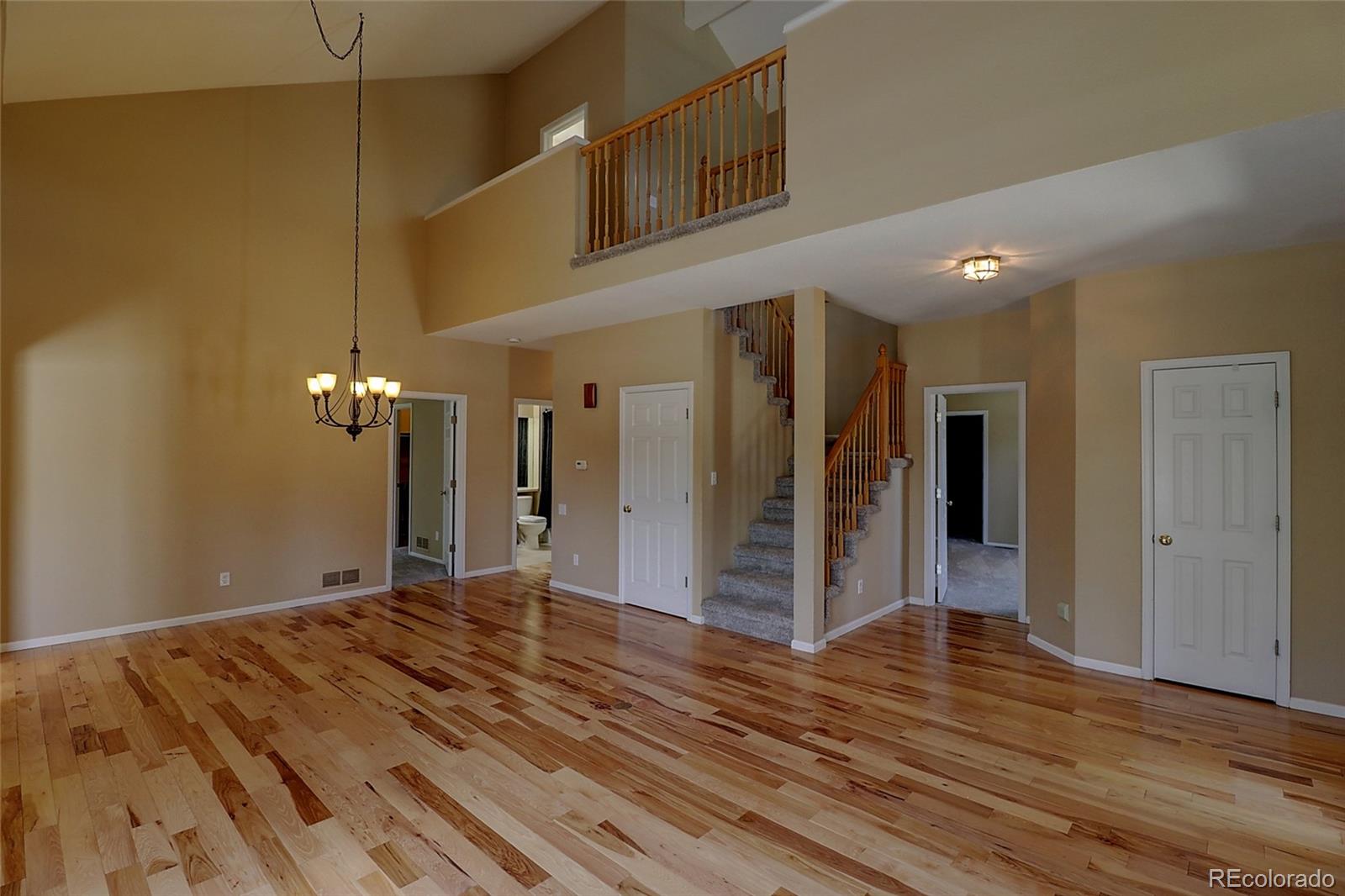 6203 Trailhead Road Highlands Ranch, CO 80130 - Photo 4 of 32 a view of a hallway with wooden floor and a bathroom