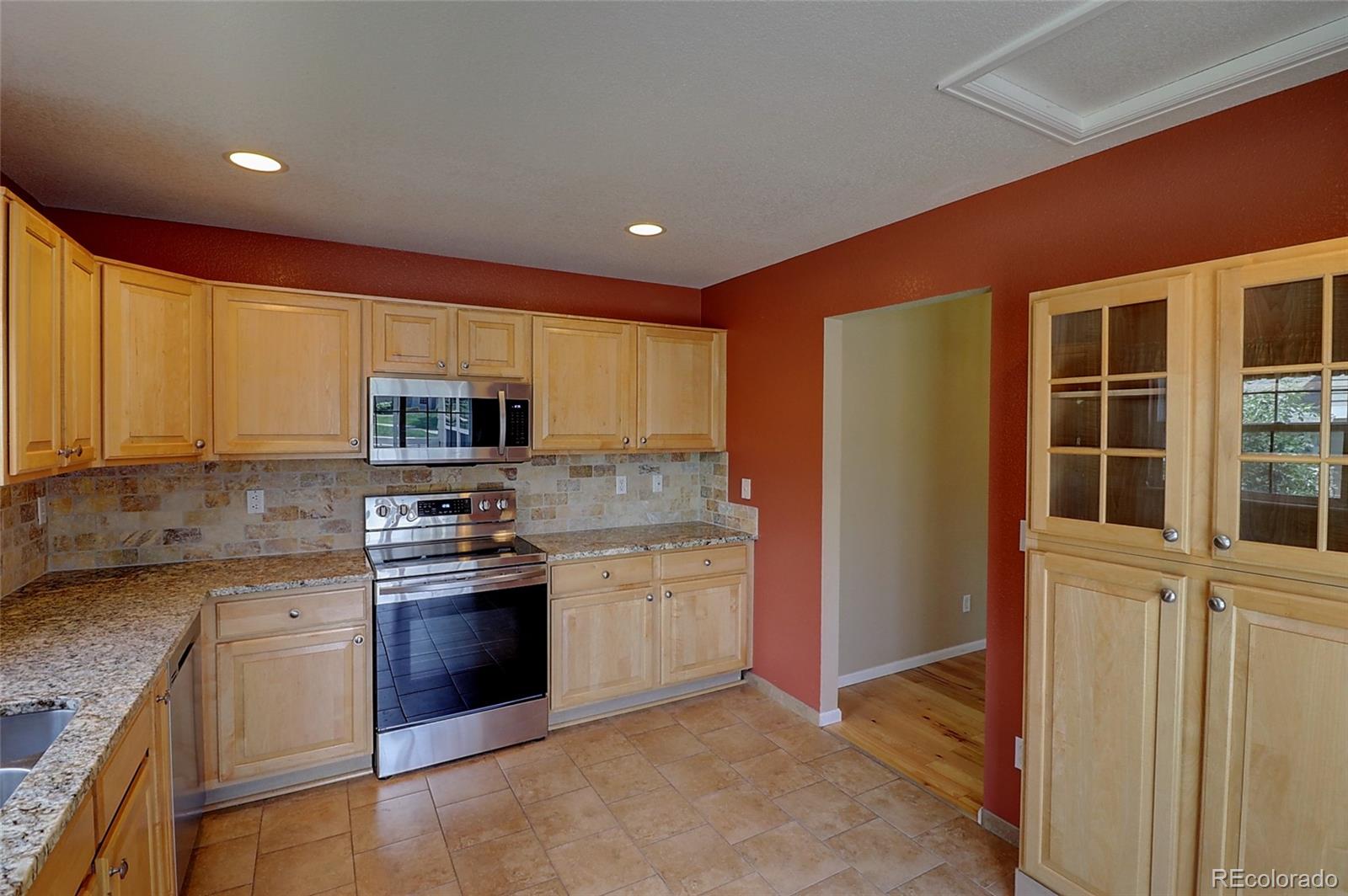 6203 Trailhead Road Highlands Ranch, CO 80130 - Photo 8 of 32 a kitchen with stainless steel appliances granite countertop a stove a sink and a refrigerator
